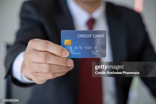 business concept:  a businessman holding the credit card in his hand - hand holding credit card stock pictures, royalty-free photos & images