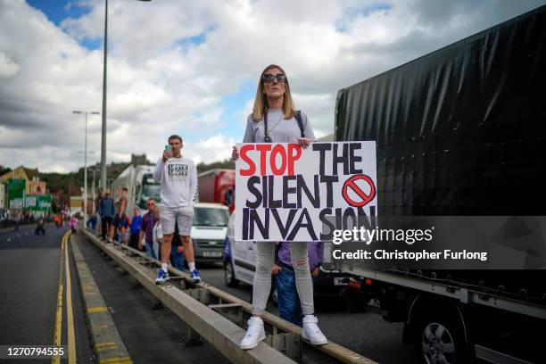 Anti-migrant protesters demonstrate against immigration and the increase in journeys made by refugees crossing the English Channel in dinghies to the...