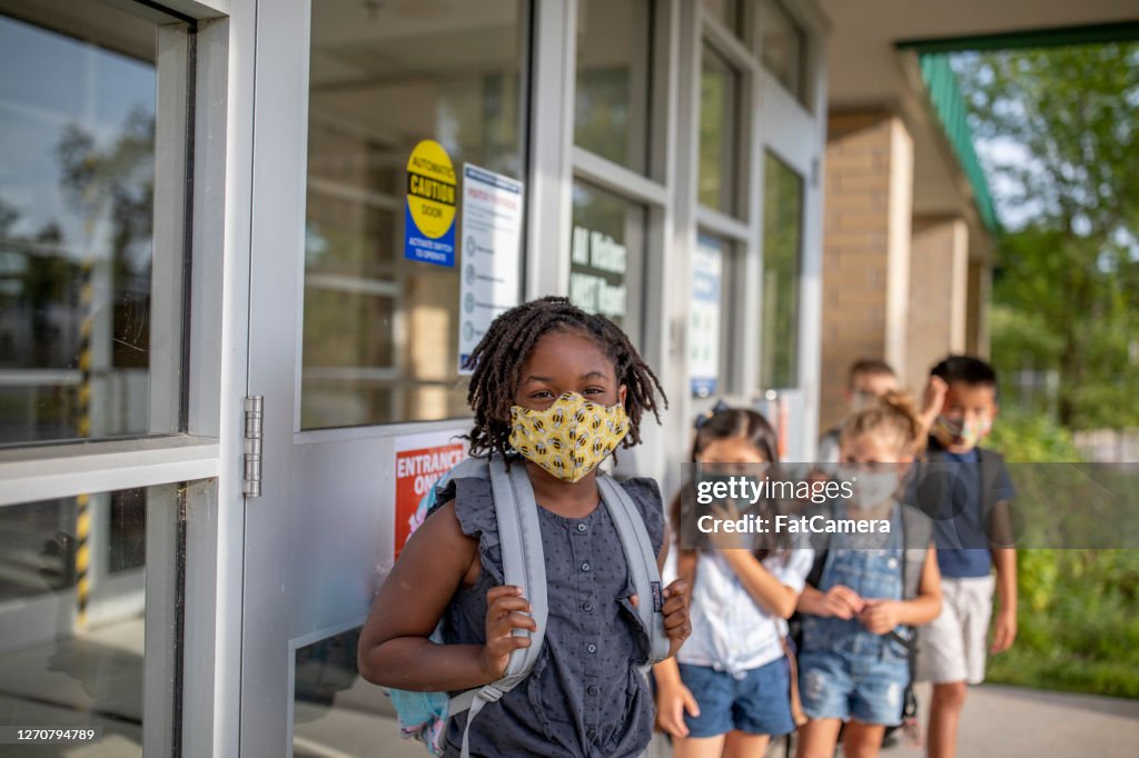Diversi gruppi di bambini delle scuole elementari tornano a scuola indossando maschere