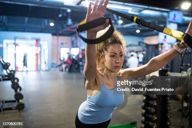young blonde woman training at the gym - brustmuskulatur stock-fotos und bilder