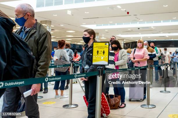 Passengers wear face masks as they arrive at Dublin Airport on August 04, 2020 in Dublin, Ireland.