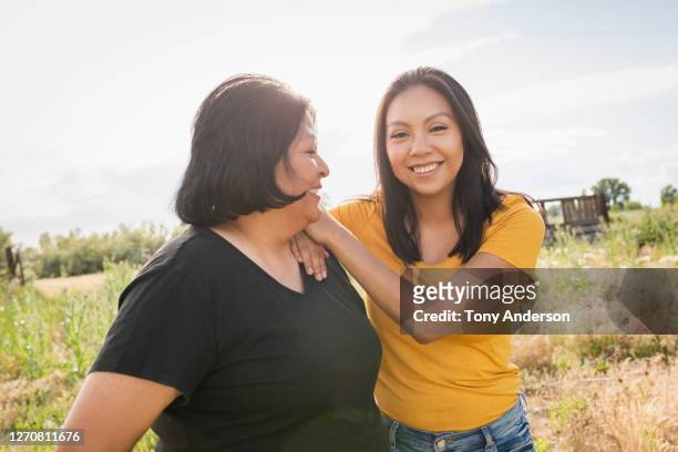 mother and adult daughter outdoors - indian mother and daughter stockfoto's en -beelden