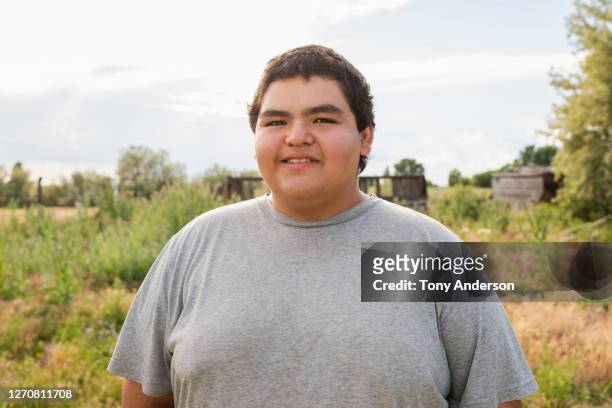 young man standing outdoors - handsome native american men stock-fotos und bilder