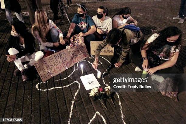Demonstrators light a candles and hold signs during a protest to demand President Ivan Duque action to stop murders of human rights activists,...