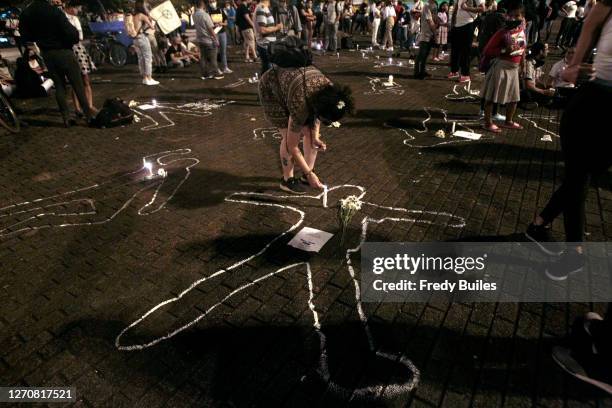 Demonstrator lights a candle during a protest to demand President Ivan Duque action to stop murders of human rights activists, indigenous people,...