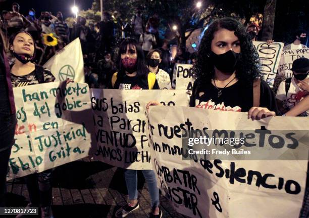 Demonstrators gather holding signs during a protest to demand President Ivan Duque action to stop murders of human rights activists, indigenous...