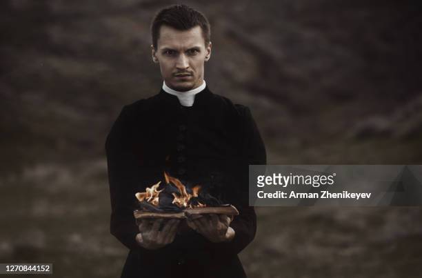 monk holding burning book - diablo dam stock pictures, royalty-free photos & images