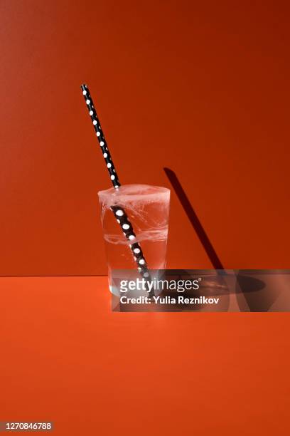 iced water in glas form on the orange background - style studio day 1 stockfoto's en -beelden