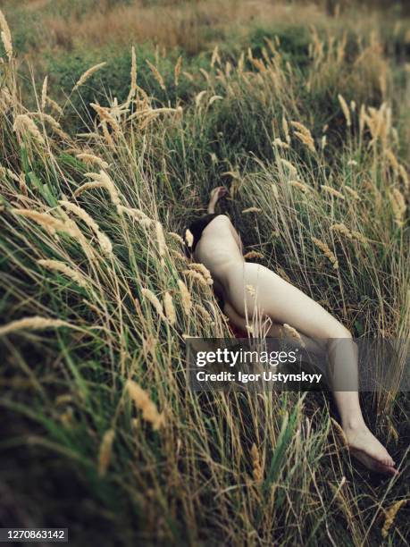 young naked woman lying on grassy field - female corpse stock pictures, royalty-free photos & images