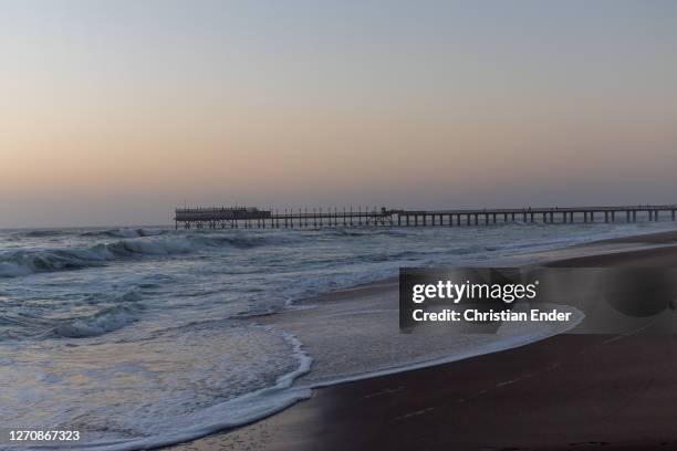 Waves wash over the shore at dusk in Swakopmund, Namibia, on April 3, 2019. Located on the coast of Namibia, Swakopmund is one of the most populous...