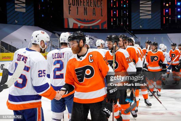 Devon Toews of the New York Islanders is congratulated by Claude Giroux of the Philadelphia Flyers after the Islanders won 4-0 to clinch the series...