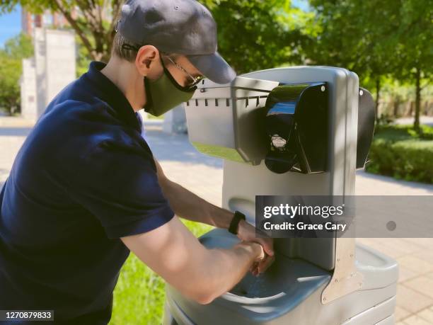 man washes hands outdoors during covid-19 pandemic - washing hands close up stock pictures, royalty-free photos & images