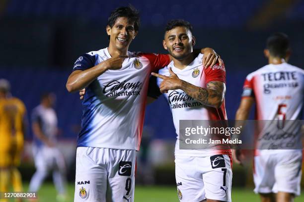 Jose Macias of Chivas celebrates with Alexis Vega after scoring the second goal of his team during the 8th round match between Tigres UANL and Chivas...
