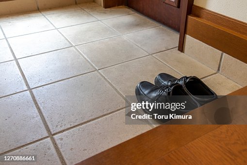 A pair of black shoes placed at the entrance A pair of black shoes placed at the entrance