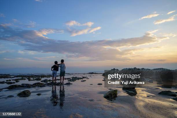 brothers playing on the beach at beautiful sunset - chiba city foto e immagini stock