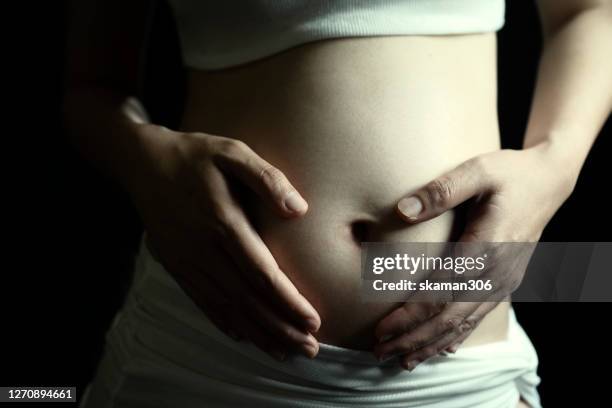 beautiful close up of pregnant woman's touching belly and waiting until new life born - miscarriage stock pictures, royalty-free photos & images