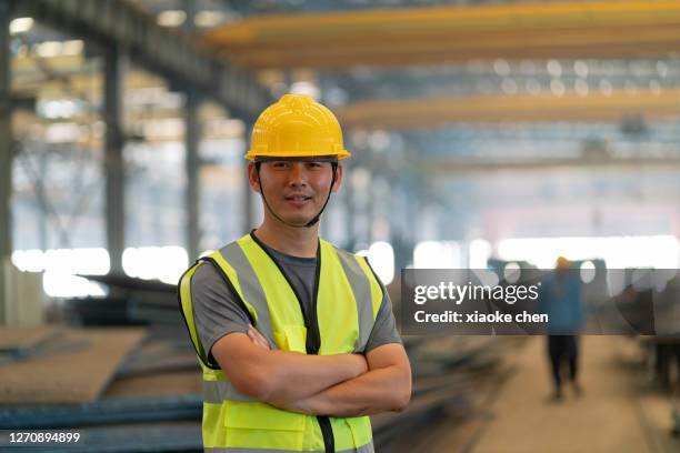 an asian male engineer smiles and looks at the camera - unemployment benefits stock pictures, royalty-free photos & images