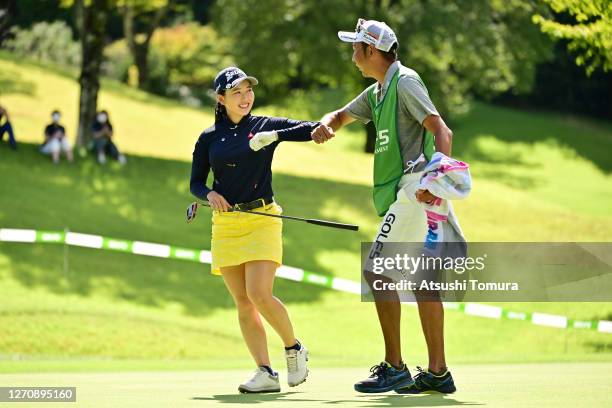 Sakura Koiwai of Japan elbow bumps with her caddie after winning the tournament on the 18th green during the final round of the GOLF5 Ladies...