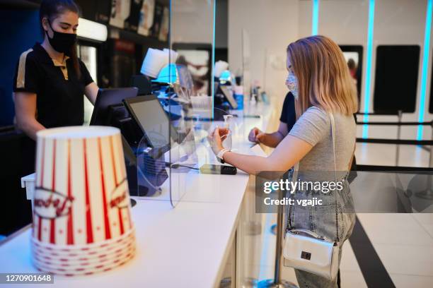 Reopening Cinema After Coronavirus Pandemic - Teenage Couple At Concession Stand In Cinema