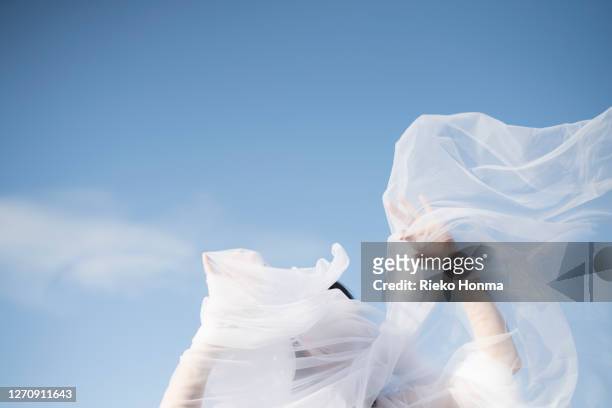 woman with white veil blowing over face - coprire foto e immagini stock