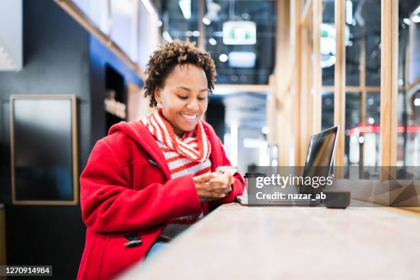 femme utilisant le manteau rouge vérifiant qu’il téléphone. - new zealand money photos et images de collection