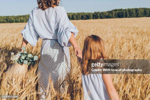 little daughter and mother enjoying summer in rye field, august village lifestyle sunny day - village stockfoto's en -beelden