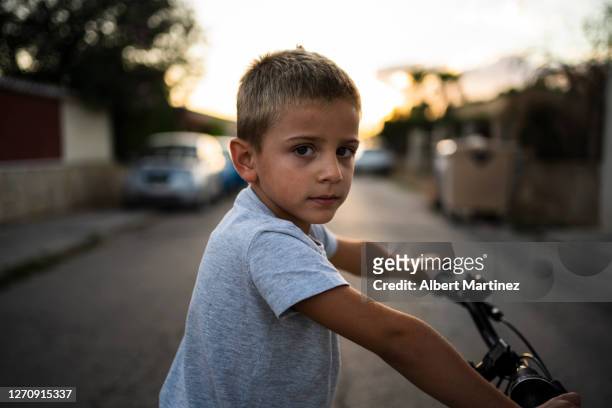 portrait of boy on bike at sunset. 5 year old boy looking at camera on his bike - 正中縦断 ストックフォトと画像