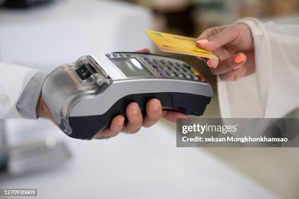 pharmacist accepting credit card by contactless payment. - airport terminal stock pictures, royalty-free photos & images