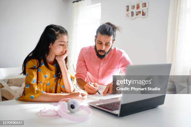 papá ayudar a su hija con la tarea en casa - iranian girl fotografías e imágenes de stock