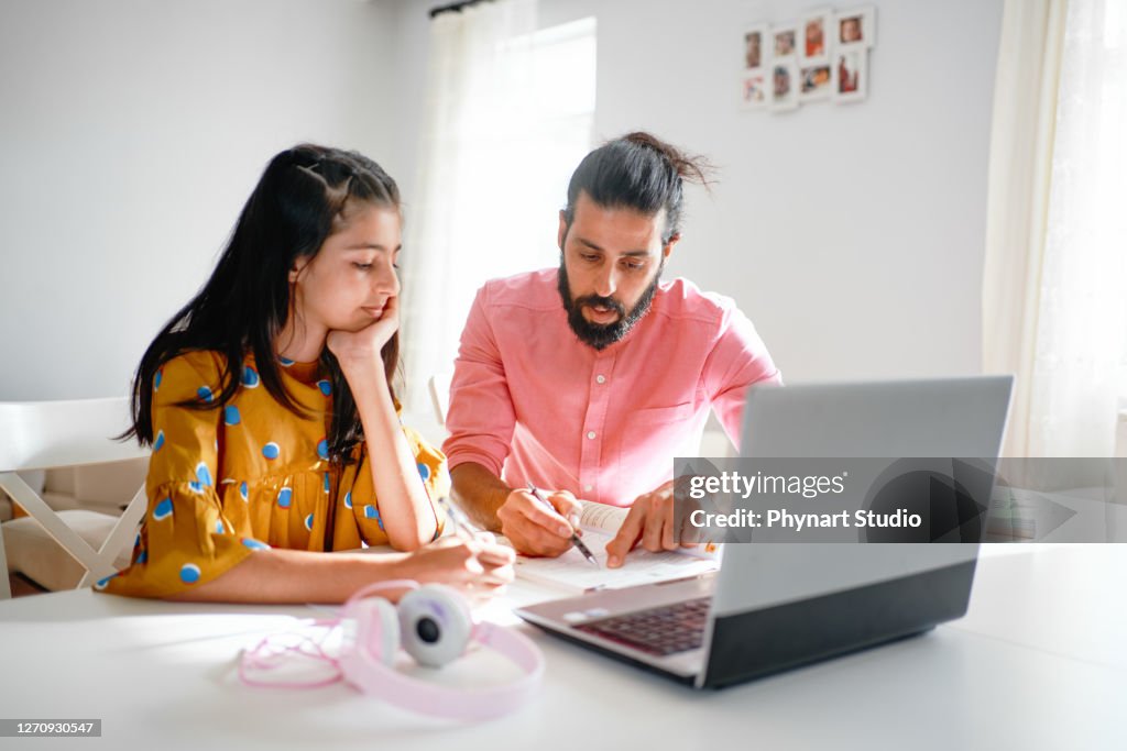 Dad help daughter with homework at home