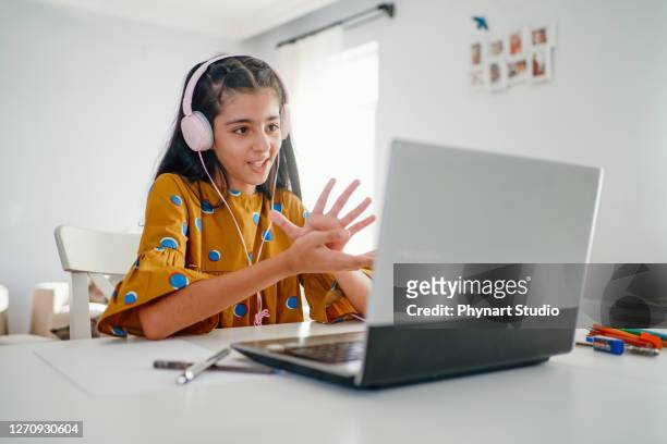teenage girl with headphones and laptop having online school class at home - teenage girls stock pictures, royalty-free photos & images