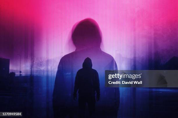 a double exposure of a silhouette of a mysterious hooded figure without a face. standing in a city at night. with a glitch, neon edit - kriminell bildbanksfoton och bilder