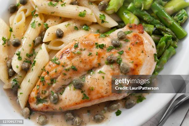 grilled chicken piccata with penne pasta and asparagus - lemon chicken stock pictures, royalty-free photos & images