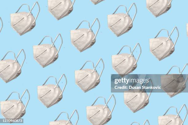 the protective mask n95 is repeated on a blue background - n95 face mask stock illustrations