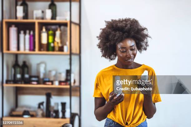 dieses produkt klingt toll! - hairdressers black woman stock-fotos und bilder