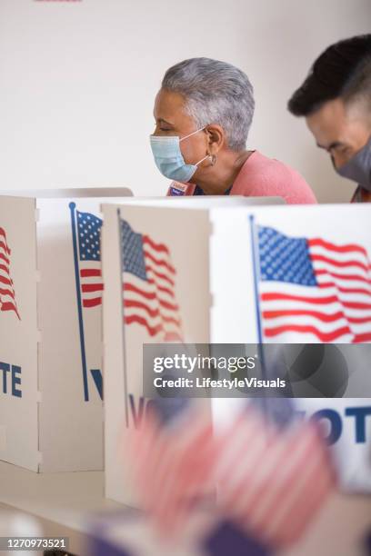 voters placing their ballots.  wearing face masks. - voter registration stock pictures, royalty-free photos & images