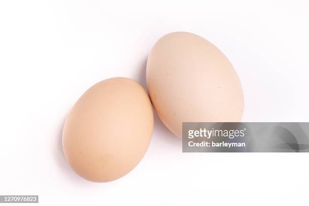 close up two red eggs on a white background - animal egg stock pictures, royalty-free photos & images