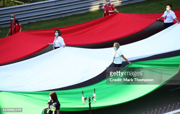 The Italian flag is brought onto the track before the F1 Grand Prix of Italy at Autodromo di Monza on September 06, 2020 in Monza, Italy.