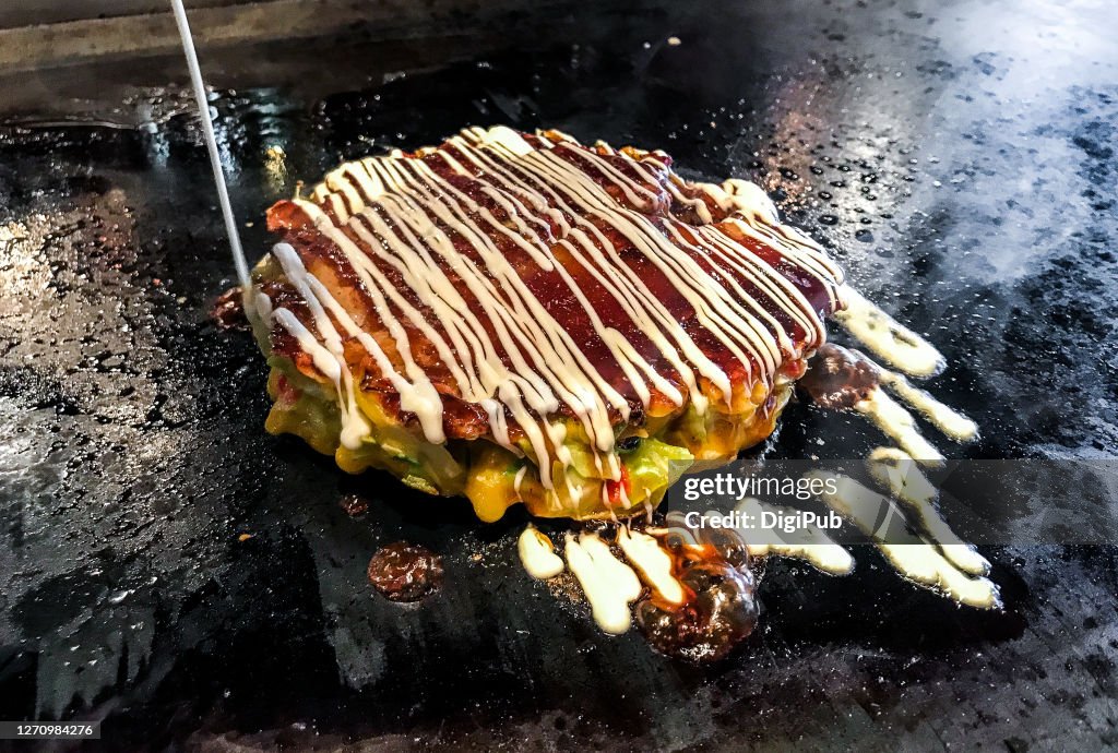 Pouring mayonnaise on okonomiyaki