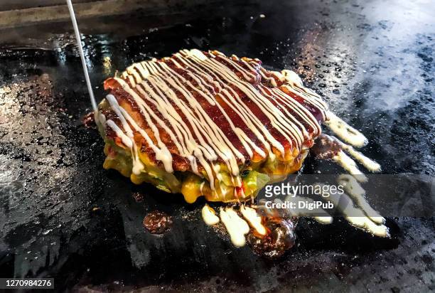 pouring mayonnaise on okonomiyaki - okonomiyaki stock pictures, royalty-free photos & images