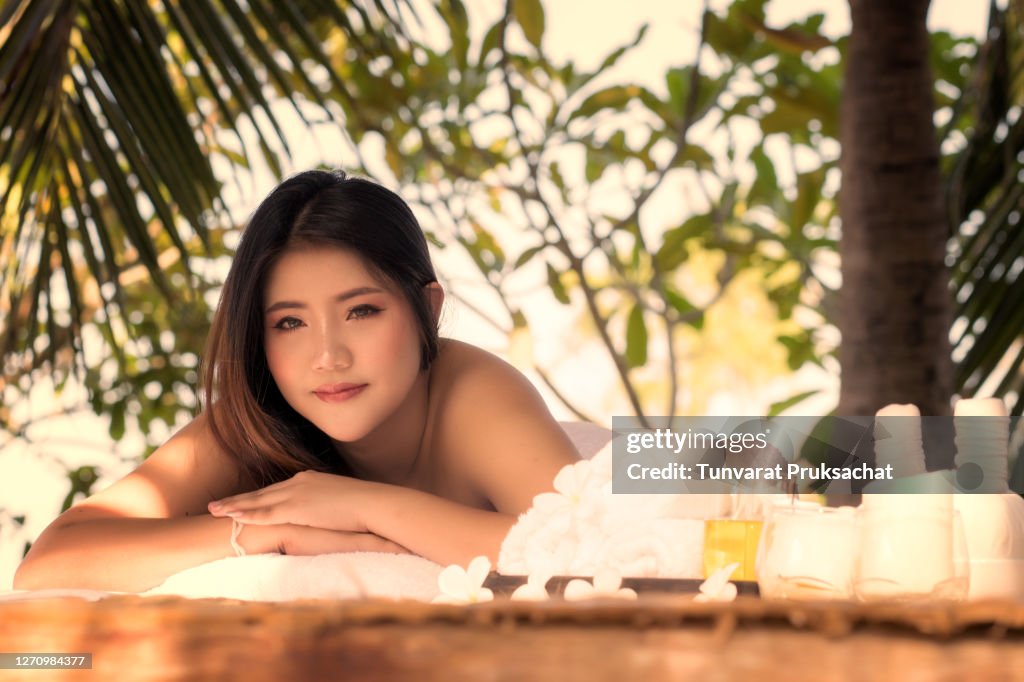 Portrait of young beautiful Asian woman relaxing Massage and spa on a wooden bed.