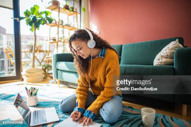 woman working online from her living room - dominican ethnicity stock pictures, royalty-free photos & images