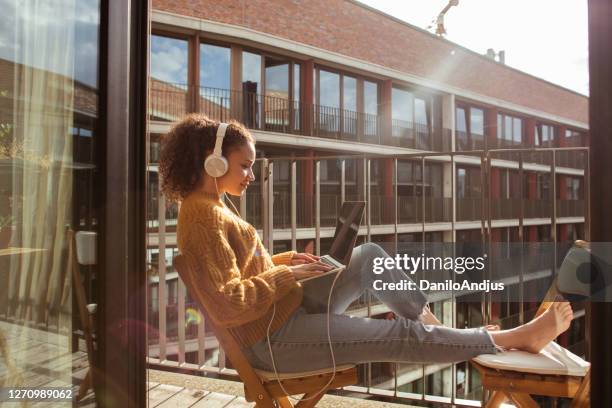 de vrouw werkt van huis op laptop - balcony stockfoto's en -beelden