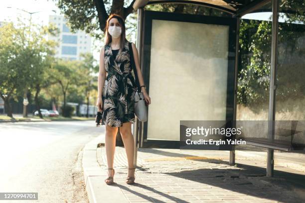 onderneemster met beschermend gezichtsmasker en het zoeken naar een bus - bus advertising stockfoto's en -beelden