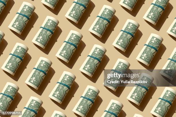 roll of american dollars banknotes on the beige background - money ahead stock-fotos und bilder