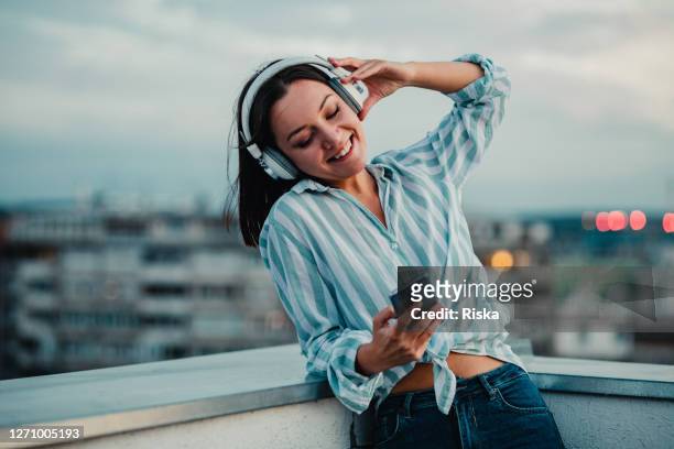 young woman listening music with headphones and enjoying in freedom - radio listening stock pictures, royalty-free photos & images