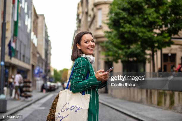 mujer moderna en la calle, regresando del trabajo - vida en la ciudad fotografías e imágenes de stock