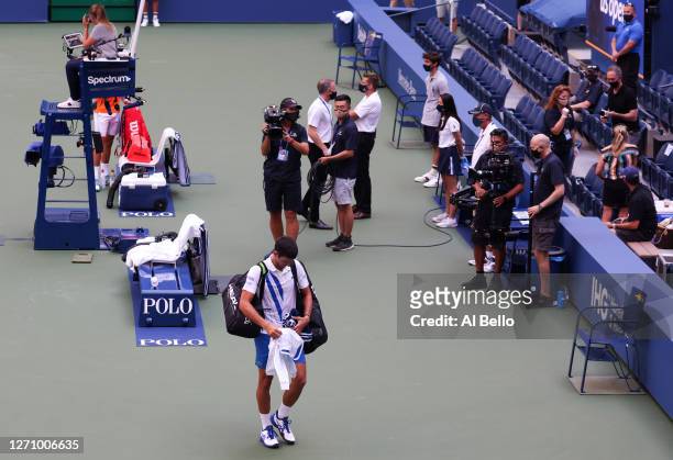 Novak Djokovic of Serbia walks off the court after being defaulted due to inadvertently striking a lineswoman Laura Clark with a ball hit in...