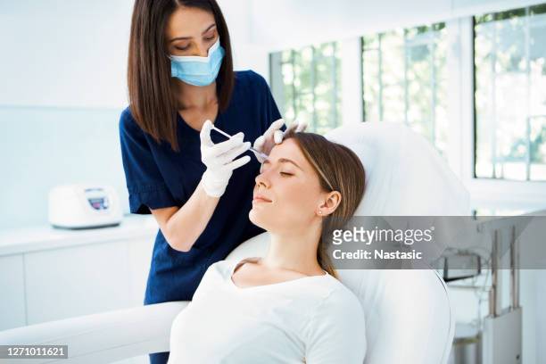 woman receiving botox injection - botox injection stock pictures, royalty-free photos & images