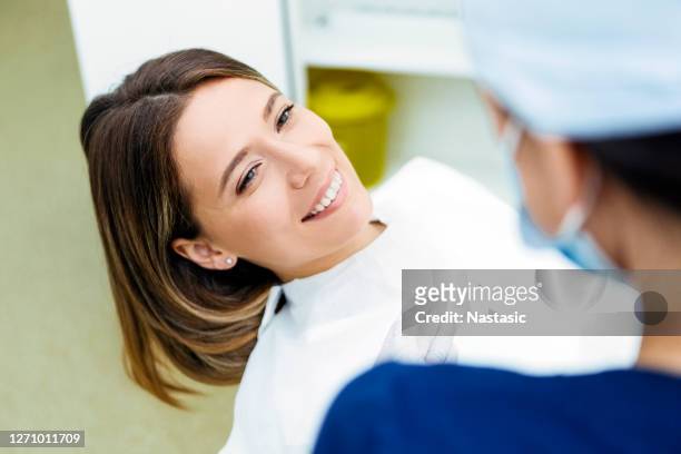 female dentist talking to a patient before dental examination - dental imaging stock pictures, royalty-free photos & images